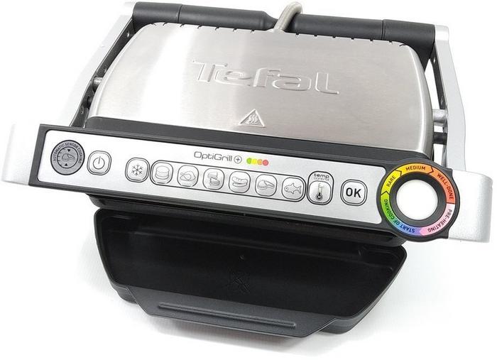 Na obrazku znajduje się Grill elektryczny TEFAL Optigrill+ GC712D w kolorze srebrno - czarnym.